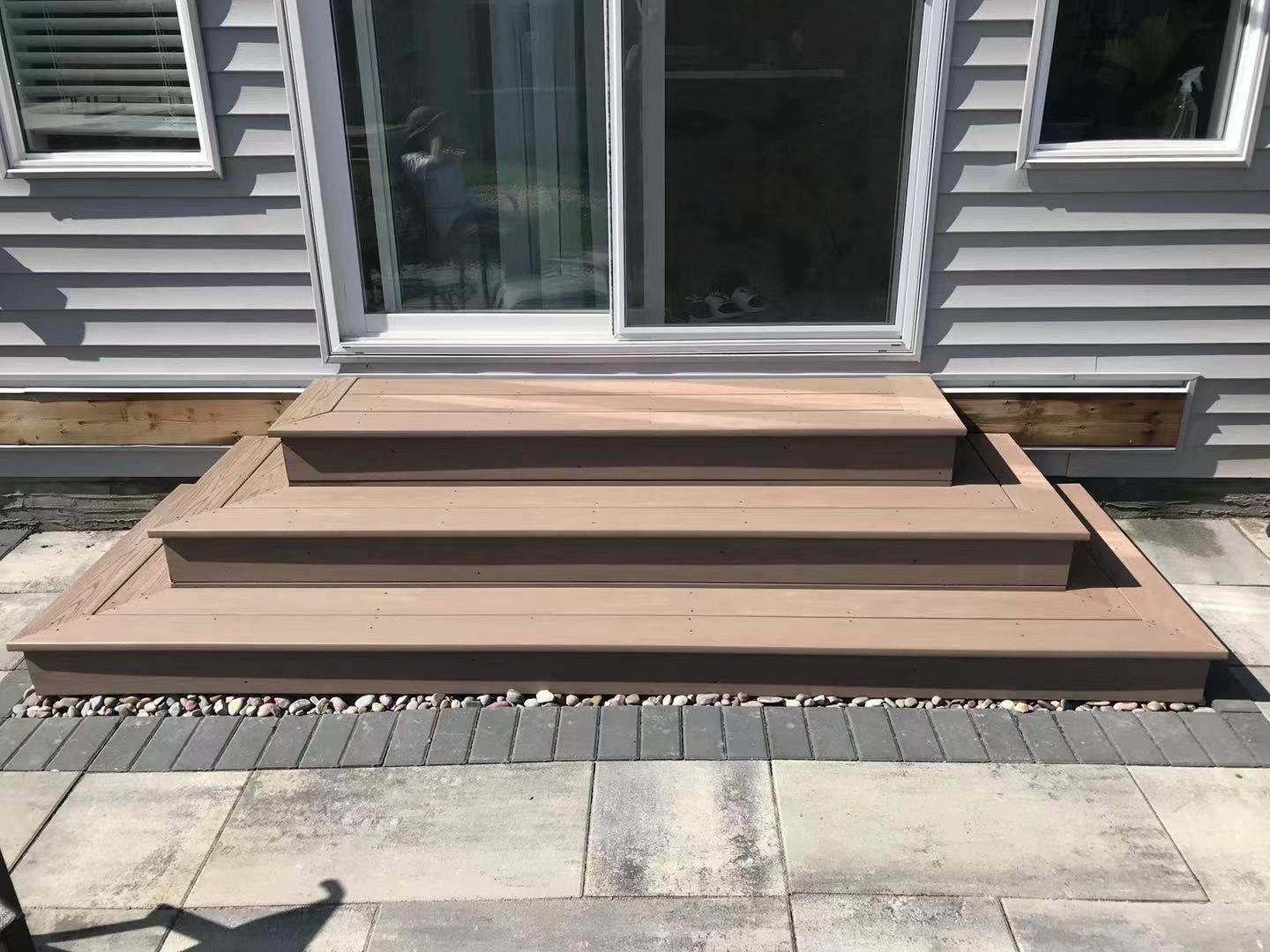 a newly constructed wood deck and iron fence in the backyard